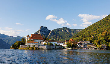 Sommerfrische auf der Halbinsel am Traunsee mit See, Häusern und Bergkulisse